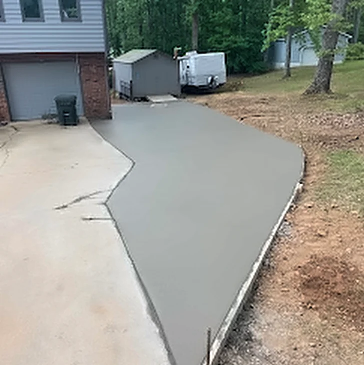 A wide finished concrete driveway running up to a garage