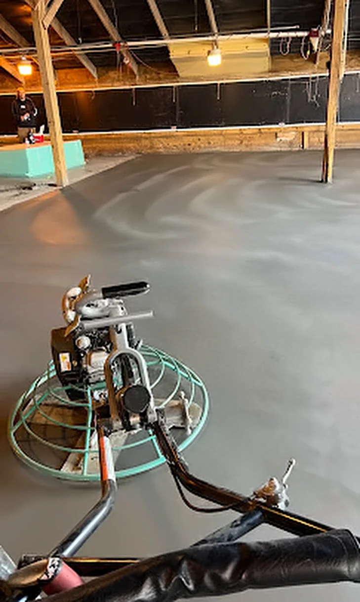 A power trowel putting a smooth swirl finish on a new interior concrete slab