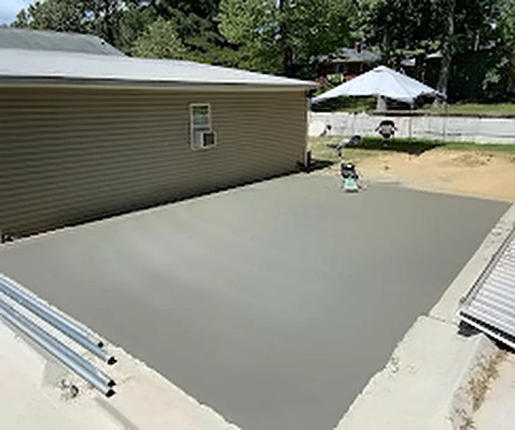 A finished concrete slab poured alongside a house